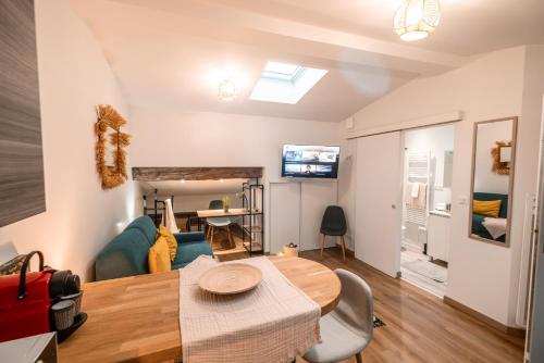 un salon avec une table et un canapé dans l'établissement Marie-Rose au Faubourg - Charmant studio en plein cœur de Montauban, à Montauban
