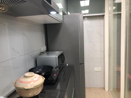 a kitchen with a microwave and a pot on a stove at 江南民居 in Suzhou