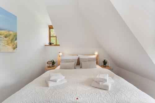 a bedroom with a white bed with two towels on it at Dornröschen 1 in Steinberg