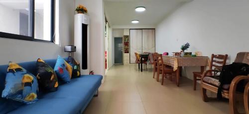 a living room with a blue couch and a dining room at 江南民居 in Suzhou