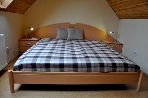a bedroom with a bed with a checkered blanket at Harcsási 60 Vendégház in Békésszentandrás