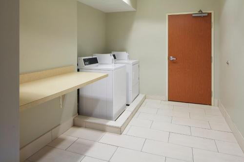 a laundry room with a washer and dryer and a door at Fairfield by Marriott Frankfort in Frankfort
