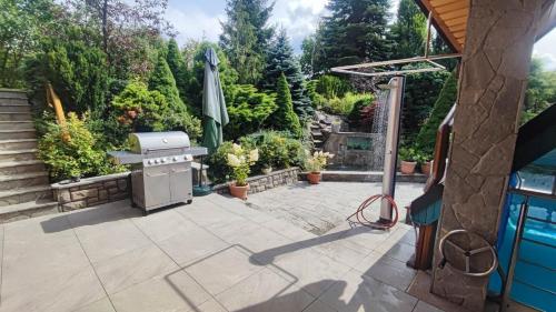 a barbecue on a patio next to a pool at Willa Chruślice-Basen sezon,Sauna in Nowy Sącz