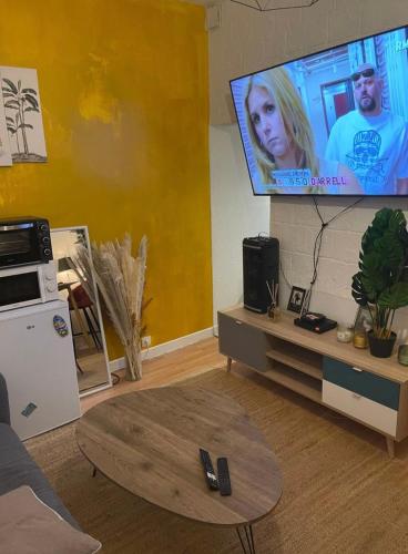 un salon avec une télévision à écran plat sur un mur dans l'établissement Magnifique T2, à Creil