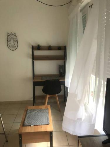 a room with a table and a chair and a desk at Studio lumineux in Nice