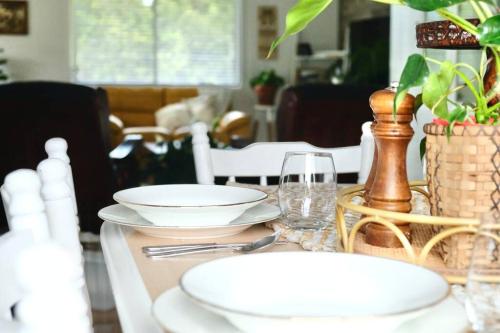 a dining room table with plates and glasses on it at 87 on Crescent in Gympie