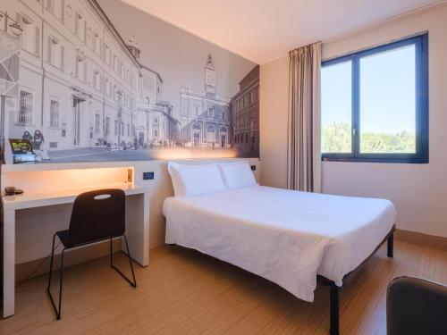 Pokój hotelowy z łóżkiem, biurkiem i oknem w obiekcie B&B Hotel Ravenna w Rawennie