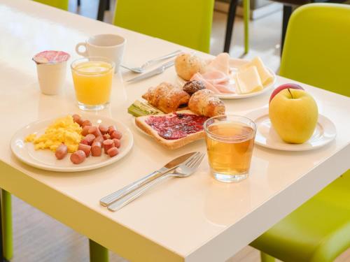 stół z talerzami jedzenia i dwie szklanki soku pomarańczowego w obiekcie B&B Hotel Ravenna w Rawennie