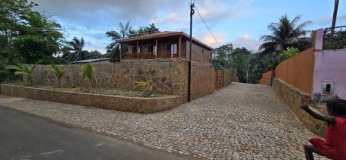 a small house on a brick wall next to a street at Moradia Pérola da Natureza in Lemos