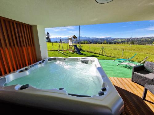 a jacuzzi tub with a view of a playground at Chałpy Na Wierchu in Rzepiska