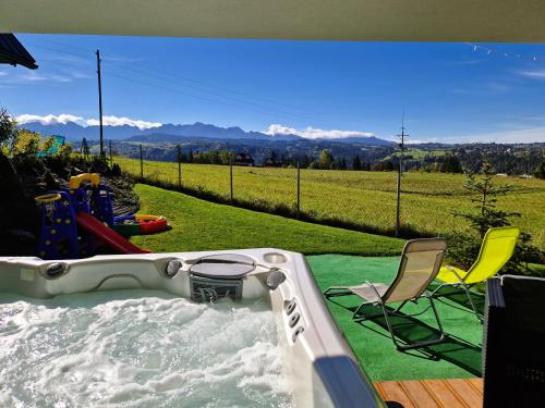 a jacuzzi tub with a chair and a table at Chałpy Na Wierchu in Rzepiska