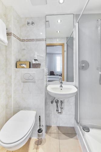a bathroom with a toilet and a sink at Hotel Weinhof in Cochem