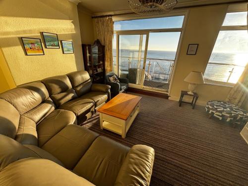 a living room with a leather couch and a table at Coble House Filey in Filey