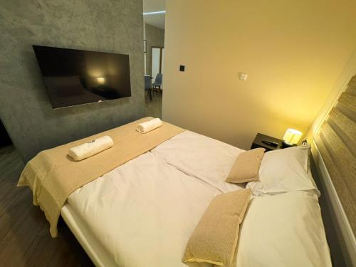 a bedroom with a large bed with two towels at Eden Spa Apartman in Arandjelovac