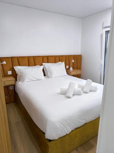 a bedroom with a large white bed with white pillows at Alojamento do Emílio in Gafanha da Encarnação
