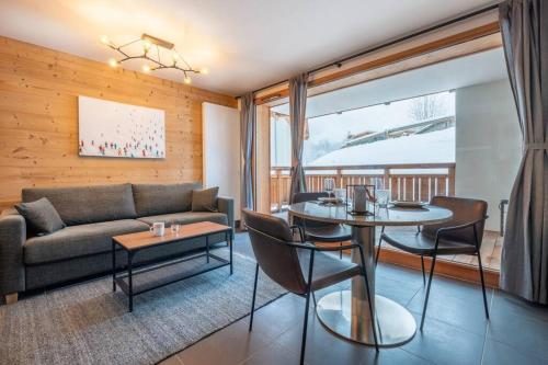 ein Wohnzimmer mit Sofa und Tisch in der Unterkunft Le Freney - New Apartment in Town Center & Free parking - By Cozee Rentals in Les Houches
