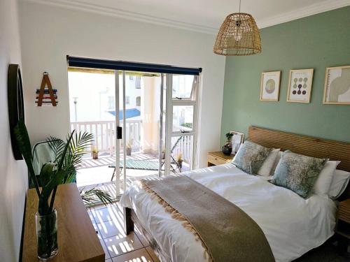 a bedroom with a bed and a balcony at Tus Nua in Langebaan