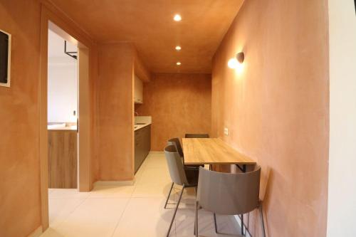 a kitchen and dining room with a wooden table and chairs at Philoxenia Apartments in Panormos Rethymno