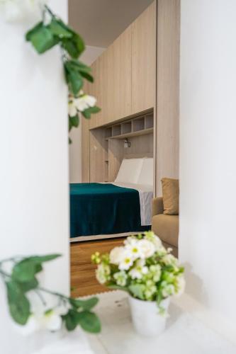 a room with a bed and a vase of flowers at Riol Home in Cesano