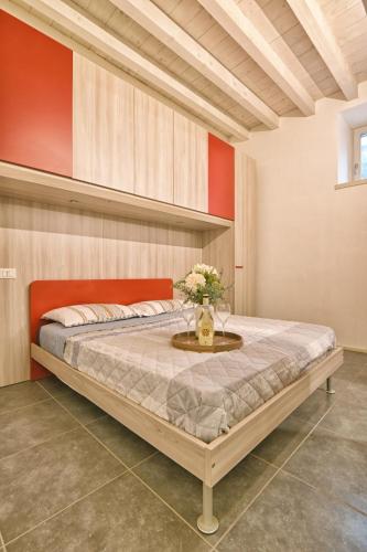 a bedroom with a bed with a vase of flowers on a table at Appartamento Simone - Theater Home in Gargnano