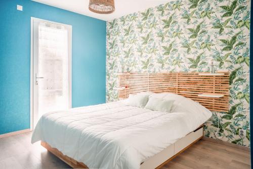 une chambre avec un grand lit aux murs bleus dans l'établissement Grande maison moderne pour 6, à Saint-Vincent-sur-Jard