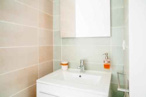 une salle de bain avec un lavabo blanc et un miroir dans l'établissement Grande maison moderne pour 6, à Saint-Vincent-sur-Jard