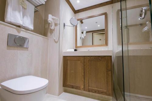 a bathroom with a toilet and a sink and a shower at Grand Hotel Huis ter Duin in Noordwijk aan Zee