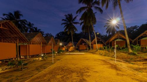 a dirt road in front of a village at night at Athgira River Camping - Udawalawe in Udawalawe