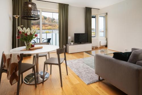 a living room with a table and a couch at BJØRVIKA APARTMENTS, Opera Area, Oslo city center in Oslo