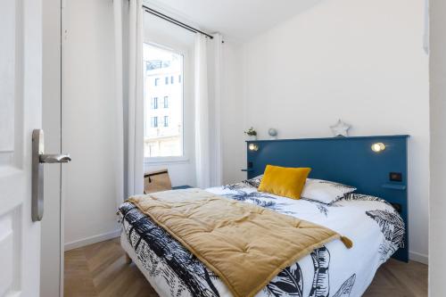 - une chambre avec un lit doté d'une tête de lit bleue et d'une fenêtre dans l'établissement 37 MASSENA LOT 2 - Superbe 3 pieces - Zone Pietonne - A-C, à Nice