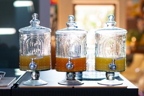 three glass jars filled with liquid on a table at Sunset Villa in Castiglione della Pescaia