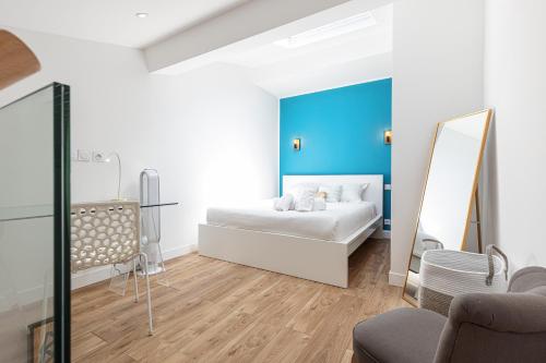 une chambre avec un lit blanc et un miroir dans l'établissement 5 FODERE - Magnifique Duplex - Port de Nice - Dernier etage, à Nice