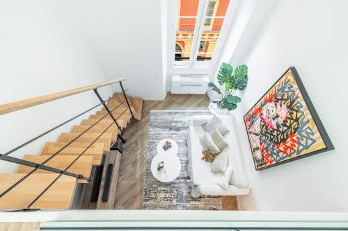 - un salon avec un canapé blanc et des escaliers dans l'établissement 5 FODERE - Magnifique Duplex - Port de Nice - Dernier etage, à Nice