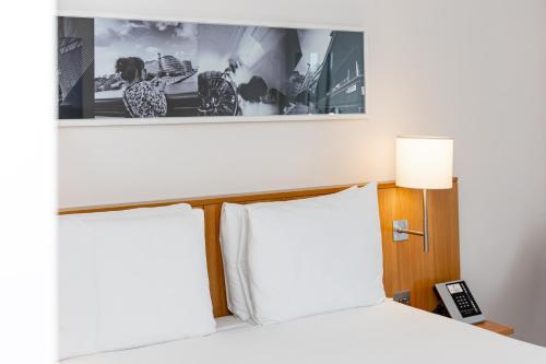 a bedroom with a bed and a picture on the wall at DoubleTree by Hilton Hotel London - Tower of London in London