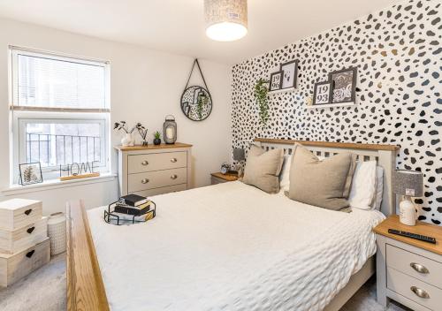 a bedroom with a white bed and a patterned wall at Modern 2 bedroom Flat in Montrose in Montrose