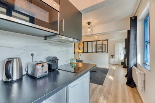 une cuisine avec un comptoir avec un micro-ondes dans l'établissement Le Golden Black à Rouen !, à Rouen