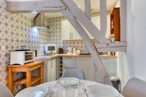 une cuisine avec une table et des chaises dans une pièce dans l'établissement Daisy Un charmant appartement près de la Place du Vieux Marché, à Rouen