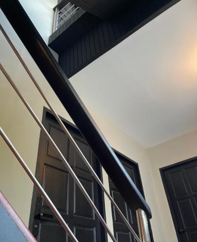a staircase with black doors in a house at GOODTHINGS Cafe & Hotel in Bophut 