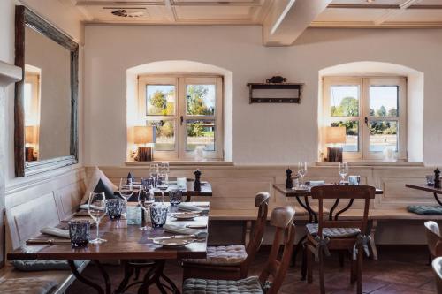 a restaurant with wooden tables and chairs and windows at Althoff Seehotel Überfahrt in Rottach-Egern