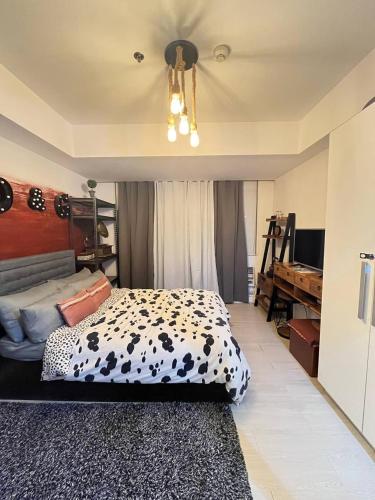 a bedroom with a cow patterned bed and a chandelier at Alphas Haven in Manila