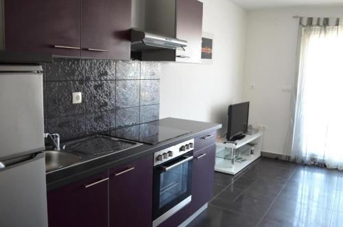 une cuisine avec un évier et une cuisinière dans l'établissement Apartments Mare, à Baška
