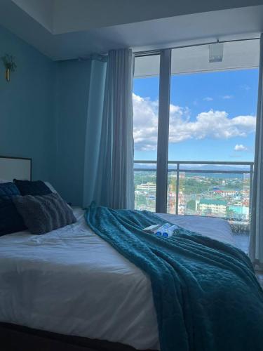 a bedroom with a bed with a large window at Alphas Haven in Manila