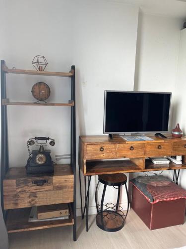 a wooden desk with a television on top of it at Alphas Haven in Manila