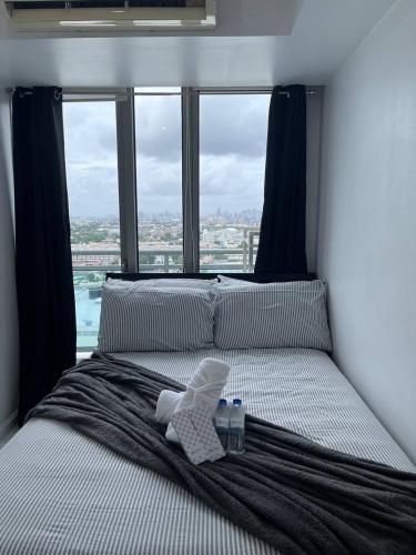 a bed with a towel on it with a window at Alphas Haven in Manila