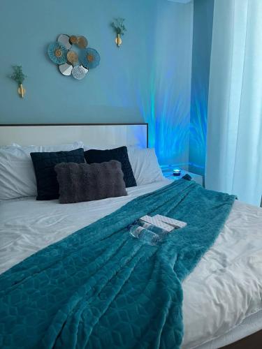 a blue bedroom with a bed with a green blanket at Alphas Haven in Manila