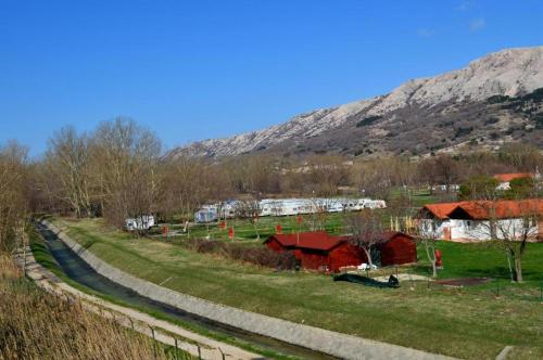 une route menant à une ferme avec des montagnes en arrière-plan dans l'établissement Apartments Mare, à Baška
