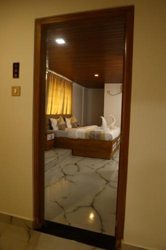a bedroom with a bed with a marble floor at Grand Tamim Hotel in Mangalore