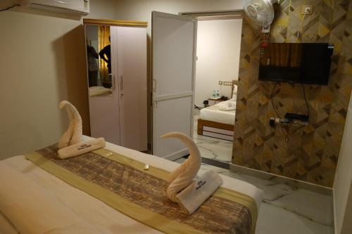 a hotel room with a bed with a mirror at Grand Tamim Hotel in Mangalore