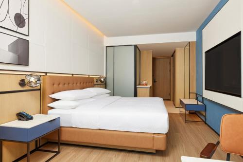 a bedroom with a bed and a flat screen tv at Four Points by Sheraton Chongqing North Railway Station in Chongqing