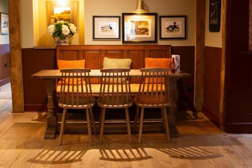 a wooden table with four chairs around it at Ye Old Boote Inn in Whittington